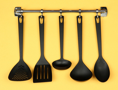 銀鉤,在黃色背景上的黑色廚房用具